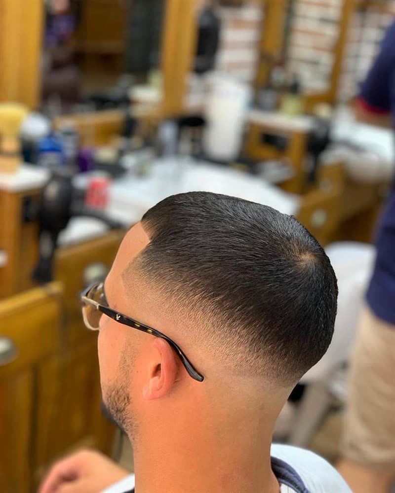 High skin fade on a client wearing glasses