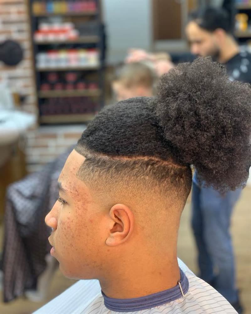 Fade with a shaved part line and afro puff